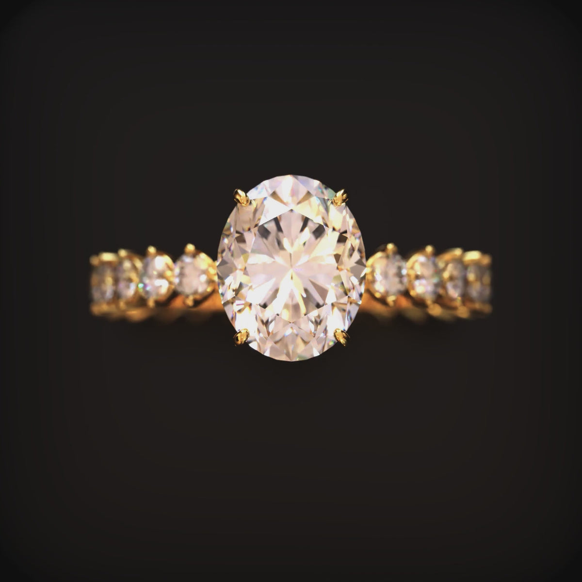A front-facing close-up of a solid gold ring with a 2 carat oval moissanite center stone and shared-prong stones along the band.