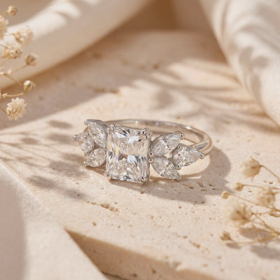 Video close-up of the silver ring with a radiant-cut center stone and marquise and pear accents on textured stone.