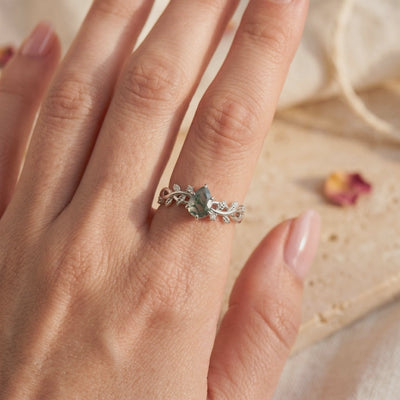Silver leaf and vine ring with a pear-cut green moss agate stone, shown worn on a hand.