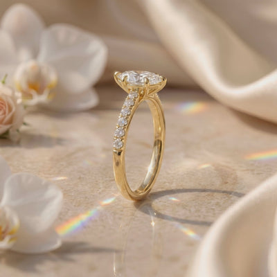 Side profile of a gold-tone marquise solitaire ring with a pavé-set band standing on a light surface.