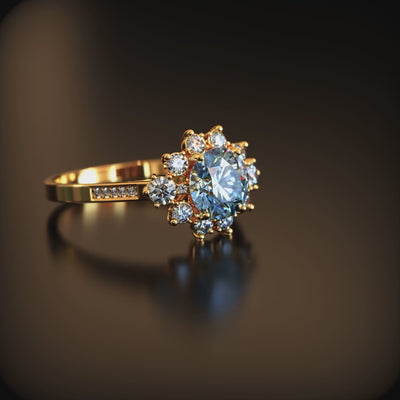 A solid gold ring with a blue moissanite center stone and halo.