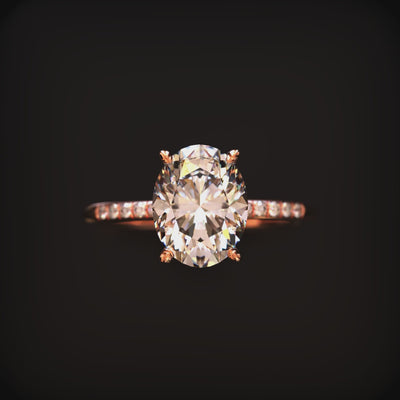 An oval moissanite ring in solid gold with a pavé band.