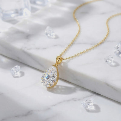 A solid gold necklace with a pear-cut A5 Zirconia pendant.