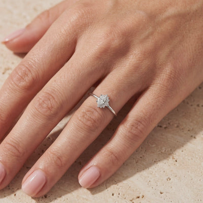 Video preview of a silver oval moissanite ring with an asymmetrical cluster worn on a hand.