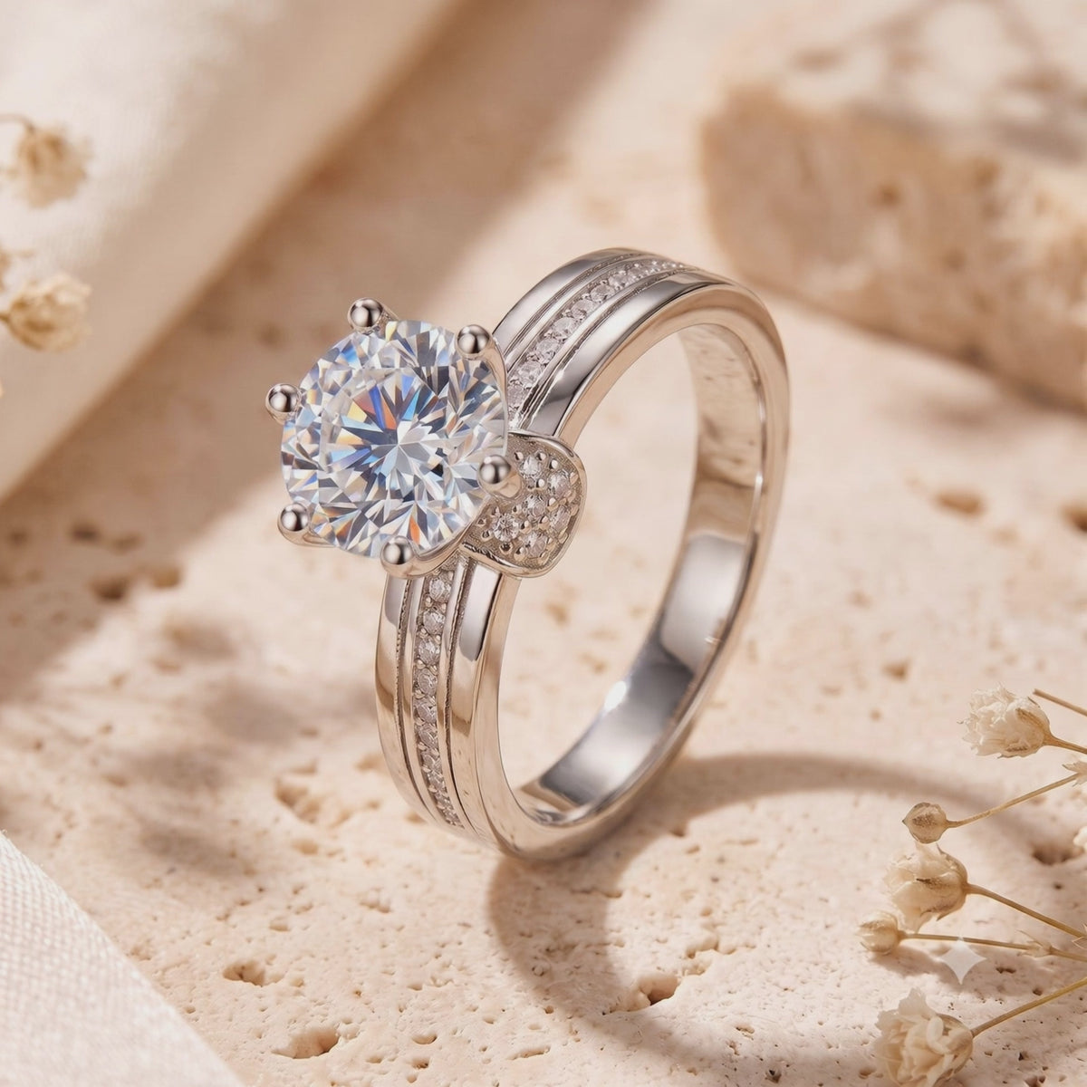 Close-up of a silver ring with a large round center stone and accent stones, standing on a textured surface.
