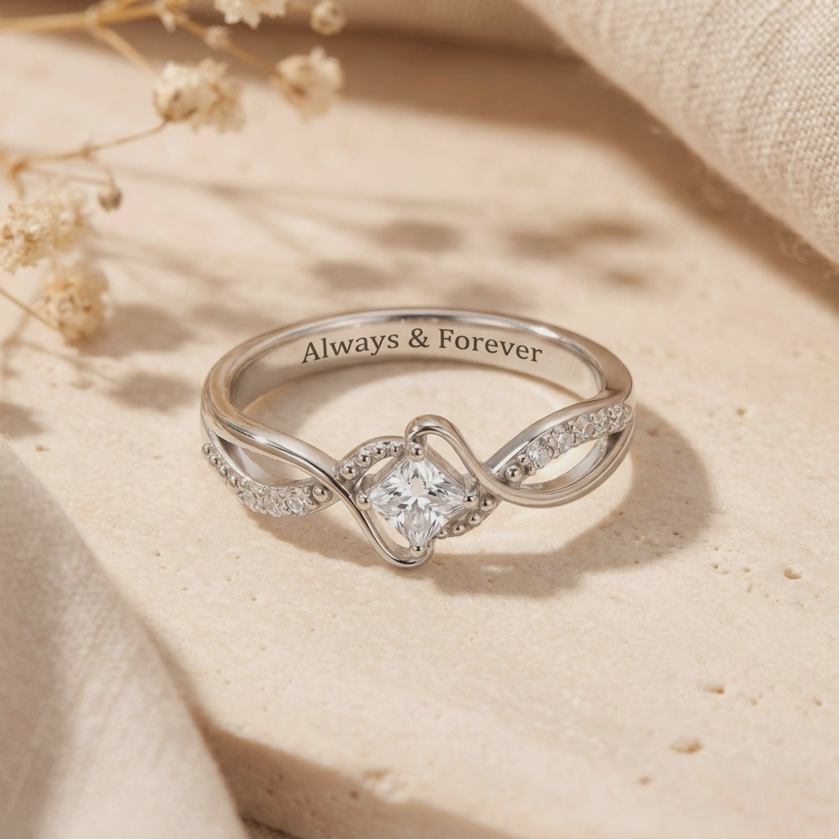 Close-up of the silver princess-cut moissanite ring displaying the inner “Always & Forever” engraving.